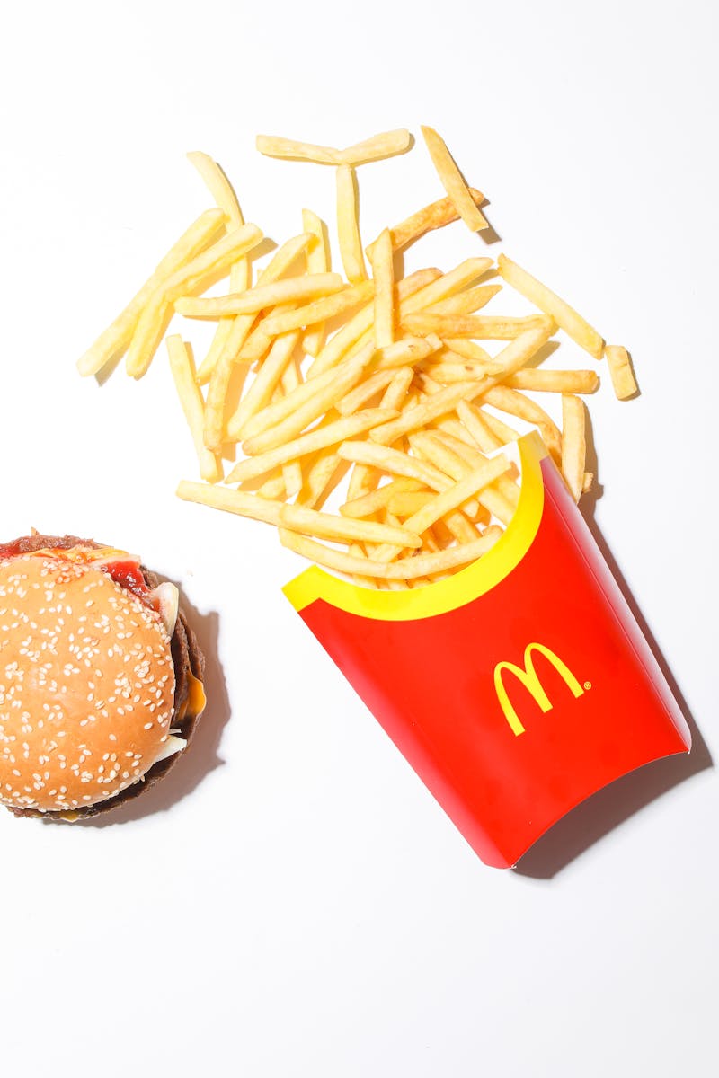 A Burger and Mcdonalds Fries on White Surface